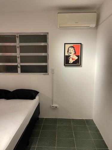 a bedroom with a bed and a picture on the wall at Acomodações do Tio Will - 2 in Guarujá