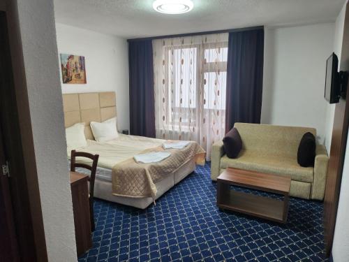 a hotel room with a bed and a chair at Guest House Stoyanov in Bansko