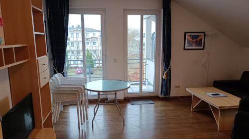 ein Wohnzimmer mit einem Tisch, Stühlen und einem Fenster in der Unterkunft Haus Südstrand in Göhren