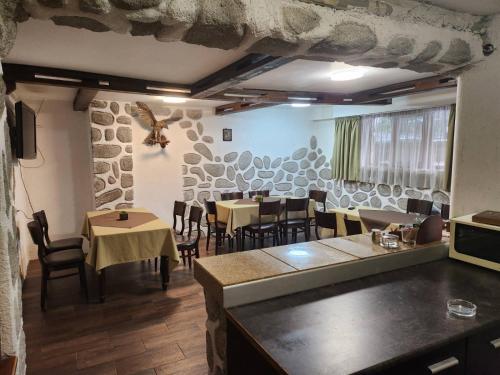 a restaurant with tables and chairs in a room at Guest House Stoyanov in Bansko