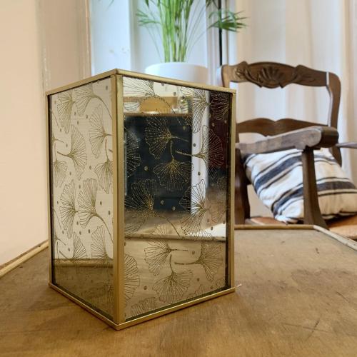 a glass box on a table with a chair at Appartements 4 vents by La Boîte En Plus in Senlis