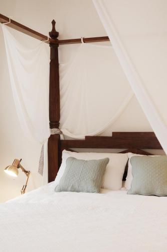 a bedroom with a bed with white sheets and pillows at Appartements 4 vents by La Boîte En Plus in Senlis