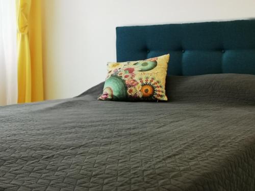 1 cama con cabecero azul y almohada en Nikos Residence, en Roman