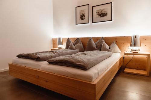 a bedroom with a large wooden bed with pillows at ALPINE LOFT Martini in Annaberg im Lammertal