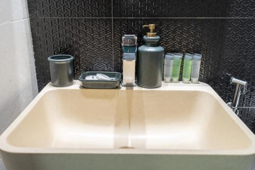 a sink in a bathroom with a bottle of soap at Placid Studio close to Dubai Miracle Garden in Dubai