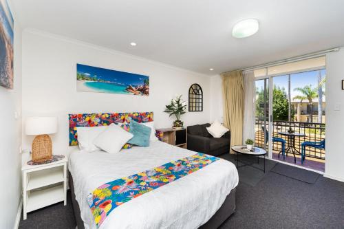 - une chambre avec un lit et un balcon dans l'établissement Seashell Studios Mandurah, à Mandurah
