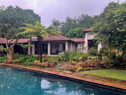 a house with a swimming pool in front of it at Ambience Inn in White River