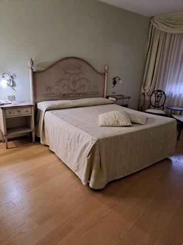 a bedroom with a large bed and a wooden floor at Hotel Internazionale in Cervignano del Friuli