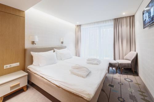 a hotel room with a bed and a chair at SPA VILNIUS Anykščiai in Anykščiai