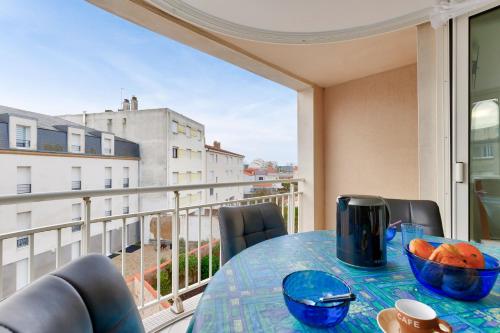 - une table sur un balcon avec vue sur un bâtiment dans l'établissement Sables d'Olonne - 450m de la plage, à Les Sables-dʼOlonne