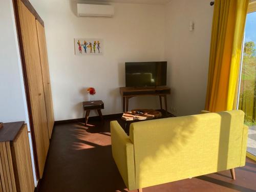 salon z żółtą kanapą i telewizorem w obiekcie Cap Mora mora w mieście Anjiabe