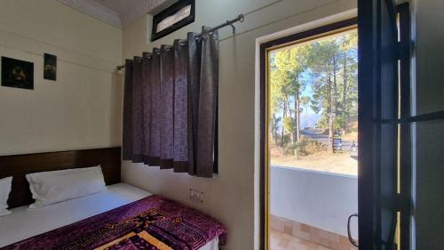 a small bedroom with a bed and a window at Starwood Hotel in Naugaon