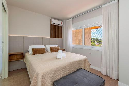 Un dormitorio con una cama grande y una ventana en Campos de Canela 402 - Stay House Temporada, en Canela