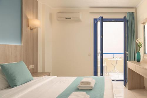 a hotel room with a bed with towels on it at Central Hersonissos Hotel in Hersonissos