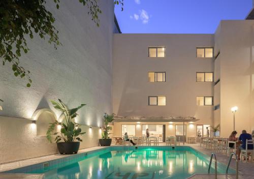 a swimming pool in front of a building at Central Hersonissos Hotel in Hersonissos