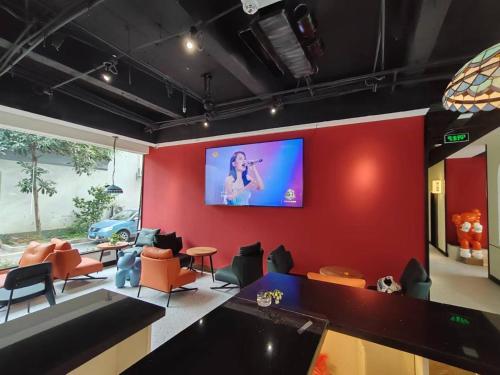 - un salon avec une télévision sur un mur rouge dans l'établissement 不负韶华青年旅馆 Youth Hostel, à Suzhou