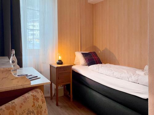 a small room with a bed and a window at DU GLACIER Boutique & Traditions Hotel in Fiesch
