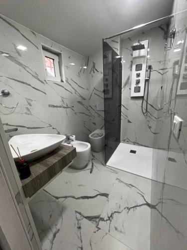 a marble bathroom with a sink and a shower at Nuova casa mini in Ravenna