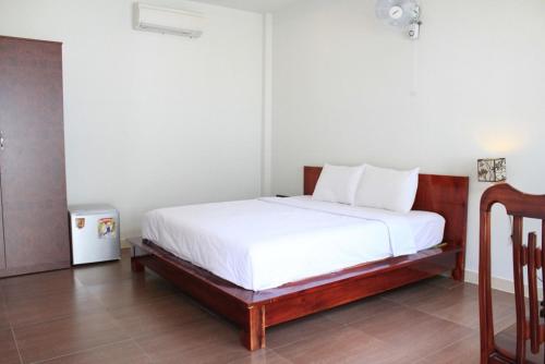 富國的住宿－陽光別墅，一间卧室配有一张白色的木架床