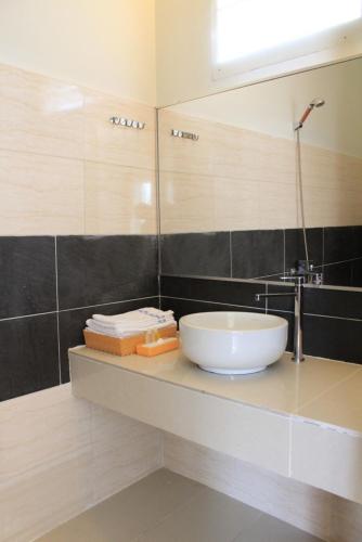 a bathroom with a sink and a mirror at Sunshine Bungalow in Phú Quốc