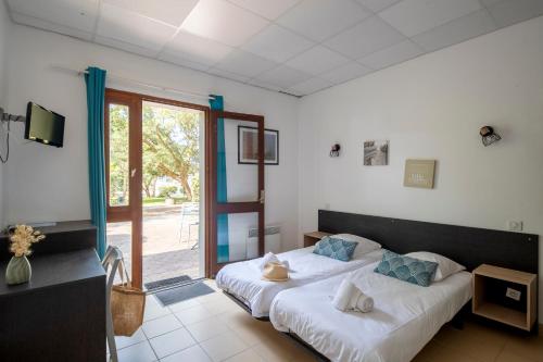 a bedroom with two beds and a sliding glass door at Cap Océan in Seignosse