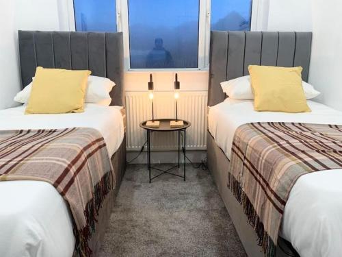 a hotel room with two beds and a table at Stylish Retreat in Leigh-on-Sea in Southend-on-Sea