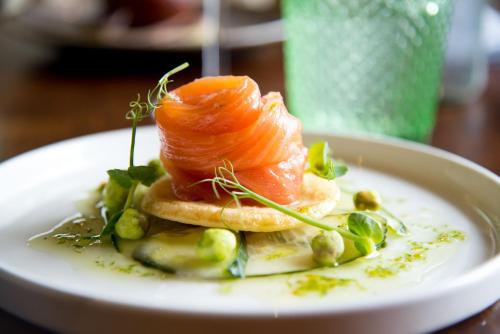 a plate of food with salmon and vegetables on a table at Knoll Tower in Shifnal