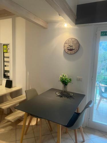 uma sala de jantar com uma mesa e um relógio na parede em Mimosas Cottage 2 Pièces eze bord de mer em Èze