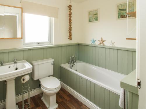 a bathroom with a tub and a toilet and a sink at Dragonfly Lodge in Shrewsbury