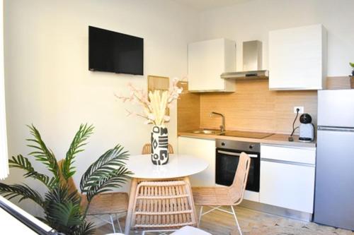 アルゲーロにあるCasa Vacanze Maiorca & Minorcaのテーブルと椅子、冷蔵庫のあるキッチン