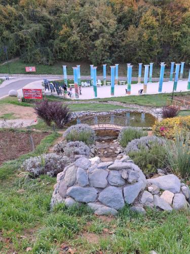 a garden with a pond and blue signs in a park at Mala farma Nani in Visoko