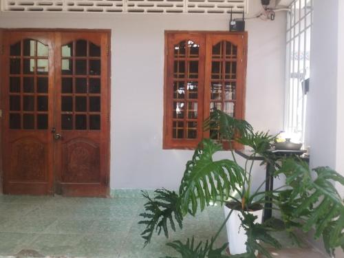 ein Haus mit zwei Türen und einer Pflanze vorne in der Unterkunft HP home & coffee in Buon Ma Thuot