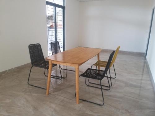 einen Holztisch und Stühle in einem Zimmer in der Unterkunft HP home & coffee in Buon Ma Thuot