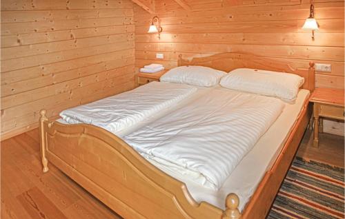a bed in a room with a wooden wall at Stunning Home In St, Stefan With 3 Bedrooms And Sauna in Elsenbrunn