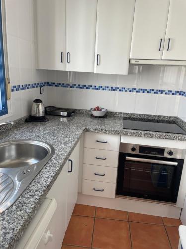 a kitchen with white cabinets and a sink at La Rosada 9 in Las Negras