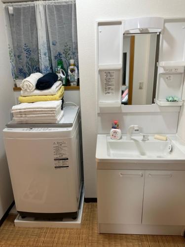 a bathroom with a sink and a washing machine at Guest House Kubo Homes Shotenshita in Osaka