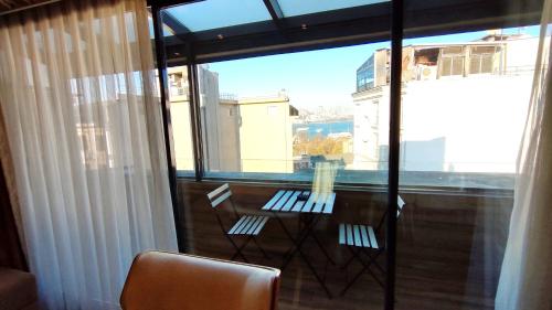 a balcony with a table and chairs and a large window at Old Port Hotel in Istanbul