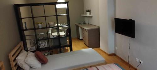 Cette petite chambre comprend un lit et une télévision. dans l'établissement short stay loft at Thessaloniki, à Thessalonique