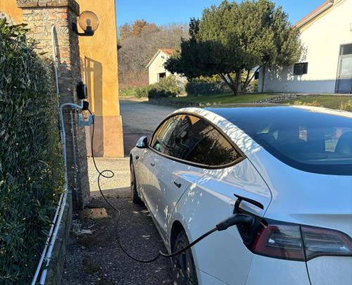 a white car is being charged in a driveway at Tenuta Le Sorgive Agriturismo in Solferino