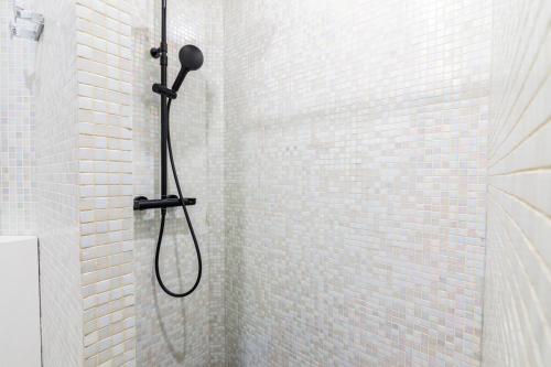 um chuveiro com uma cabeça de chuveiro preta na casa de banho em Luxurious 1 Bedroom Republique Vinaigriers em Paris