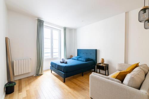 uma sala de estar com um sofá e uma cama em Luxurious 1 Bedroom Republique Vinaigriers em Paris