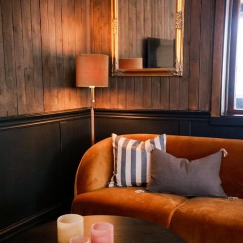 a living room with an orange couch and a table at Pensionat Mullfjället in Duved