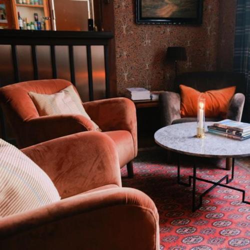 a living room with chairs and a table with a candle at Pensionat Mullfjället in Duved
