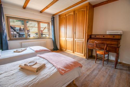 a bedroom with two beds and a desk at Duplex en ville vue château - Studio - Parking in Kaysersberg