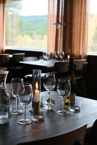 a table with wine glasses and a candle on it at Pensionat Mullfjället in Duved