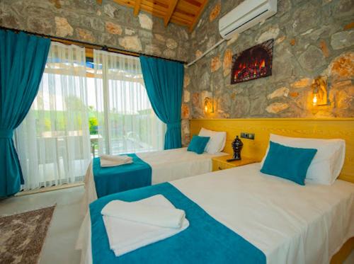 a hotel room with two beds and a fireplace at Villa Ege & villa yiğit & villa yağız - happy villaları in Fethiye