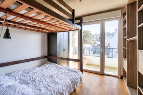 a bedroom with a bed and a large window at Vacances au pied de la plage du Val-André in Le Val-André