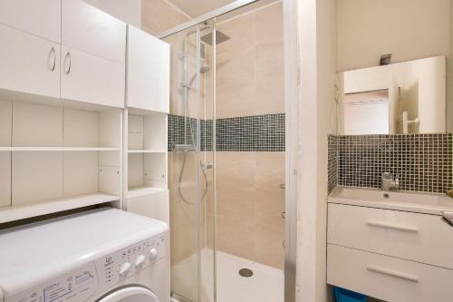 a bathroom with a shower and a washing machine at Vacances au pied de la plage du Val-André in Le Val-André