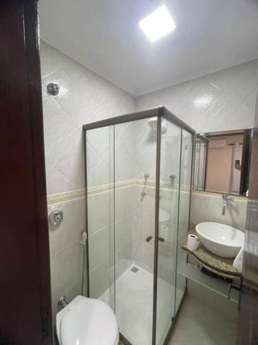 uma casa de banho com um chuveiro, um WC e um lavatório. em Ótima Casa com Piscina, Sauna e Churrasqueira em Cabo Frio