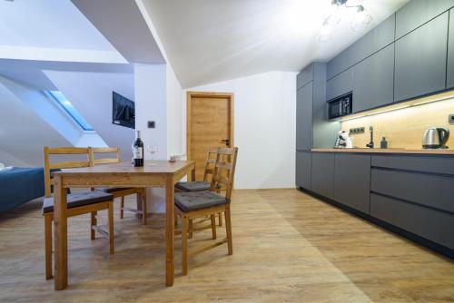 a kitchen and dining room with a wooden table and chairs at Apartmán na Hůrce in Horní Planá